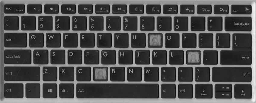 a flatbed scan of a grimy laptop keyboard missing three keys